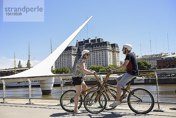 Ein Paar auf Bambus-Fahrrad vor der Puente De La Mujer am Puerto Madero in Buenos Aires  Argentinien