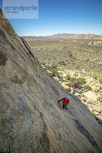 Ein kleiner Junge klettert im Joshua Tree National Park  Kalifornien  an einem technischen Kletterfelsen.