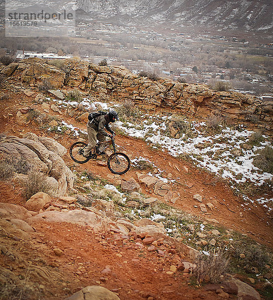 Erfahrene Fahrer fahren eine Downhill-Mountainbike-Strecke hinunter  die in die Stadt Moab  Utah  führt.