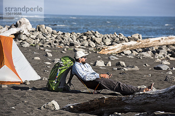 Mann entspannt sich beim Camping an der Lost Coast am Meer