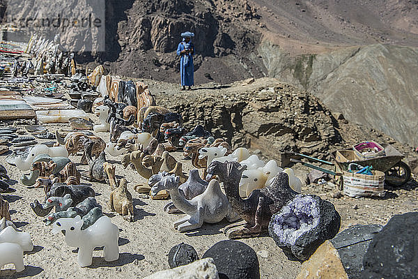 Souvenir-Figuren zum Verkauf am Straßenrand  darunter Kamele im Atlasgebirge von Marokko