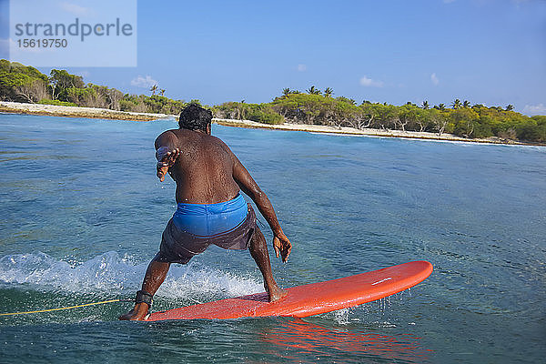 Mann ohne Hemd beim Surfen in Küstennähe  Male  Malediven