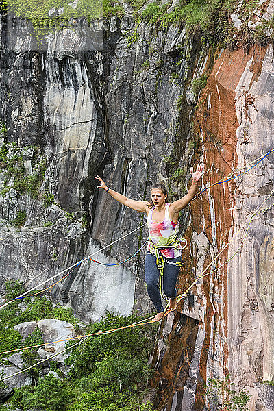 Abenteuerlustige junge Frau  die auf einer Slackline balanciert  Steinbruch Dibs  Maripora  Bundesstaat Sao Paulo  Brasilien