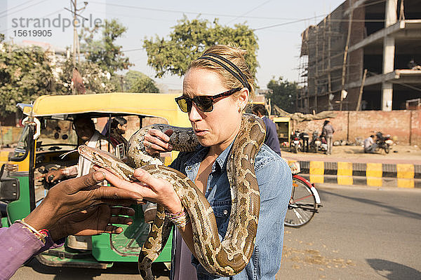 Ein amerikanisches Mädchen spielt mit einer großen Schlange in Agra  Indien.