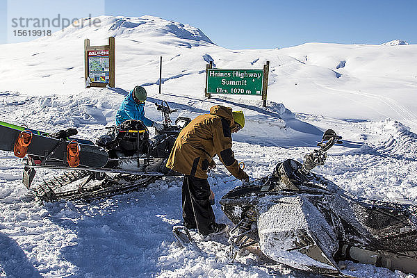 Snowboarder mit ihren Schneemobilen bei der Vorbereitung ihrer Maschinen am Haines Pass in Alaska