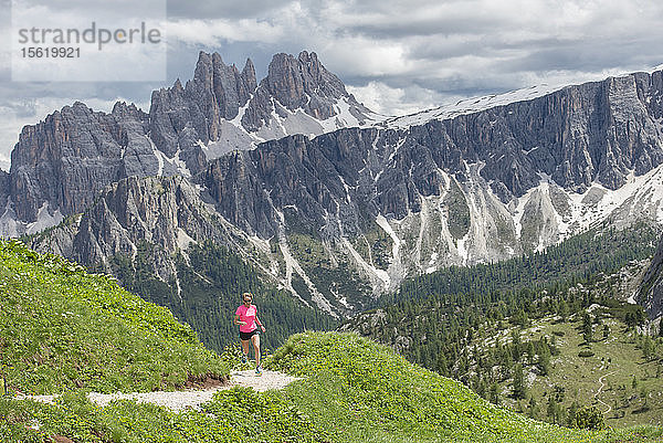 Eine Frau Trail Running bei den Cinque Torri Bereich mit der Croda Da Lago und Lastoi De Formin im Hintergrund