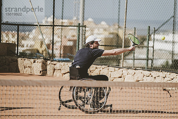 Mittlerer erwachsener österreichischer paralympischer Tennisspieler auf dem Tennisplatz