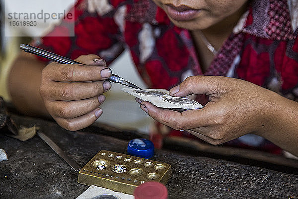 Eine Indonesierin stellt in ihrem Atelier in Ubud  Bali  Silberschmuck von Hand her.
