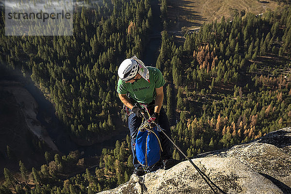 High Angle View of Male Climber Descends From Rocky Mountain