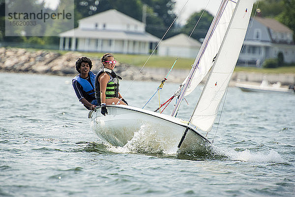 Teenager und Mädchen segeln auf einem Boot in der Narragansett Bay