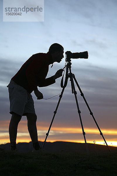 Silhouette eines Fotografen  der ein Bild zusammensetzt