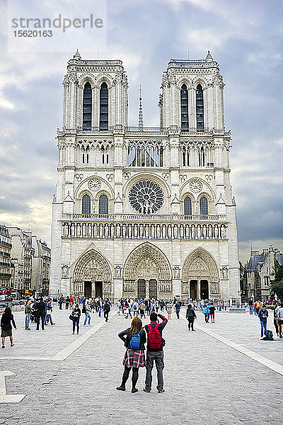 Touristenpaar beim Fotografieren der Kathedrale Notre Dame bei Sonnenaufgang  Paris  Frankreich