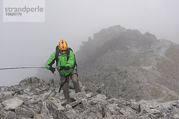 Ein Kletterer hält ein Seil an einem felsigen Abschnitt  während er auf dem Vulkan Nevado de Toluca im Estado de Mexico  Mexiko  wandert.