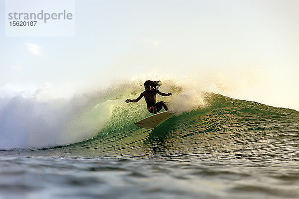 Silhouette eines Surfers auf einer Welle im Meer