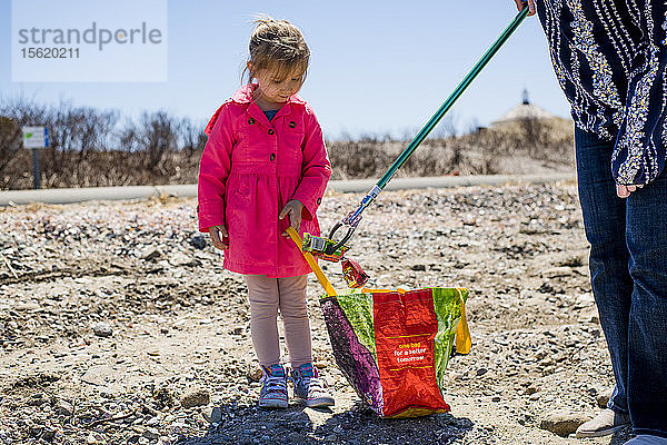 Mädchen und Erwachsener beim Aufsammeln von Müll während der Strandsäuberung am Earth Day  Portsmouth  Rhode Island  USA