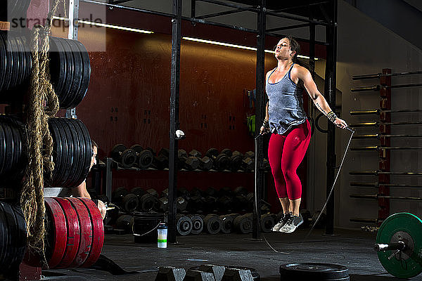 Eine Crossfit-Sportlerin springt während eines Trainings in einem Fitnessstudio in San Diego  Kalifornien  Seil.