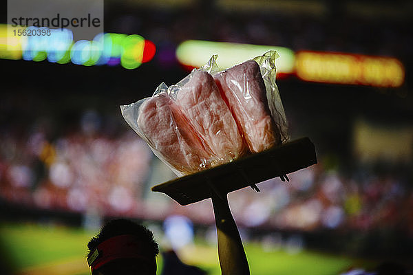 Ausschnitt aus der Rückansicht eines Verkäufers  der bei einem Baseballspiel im Angel Stadium von Anaheim  Kalifornien  rosa Zuckerwatte verkauft. USA. Weichzeichner.