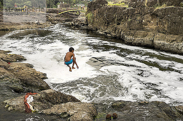 Ein Junge springt in den Fluss  Materavadi  Maharashtra  Indien.