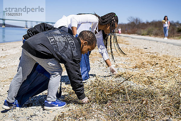 Junge und Mädchen sammeln Müll während der Strandsäuberung am Earth Day auf  Portsmouth  Rhode Island  USA