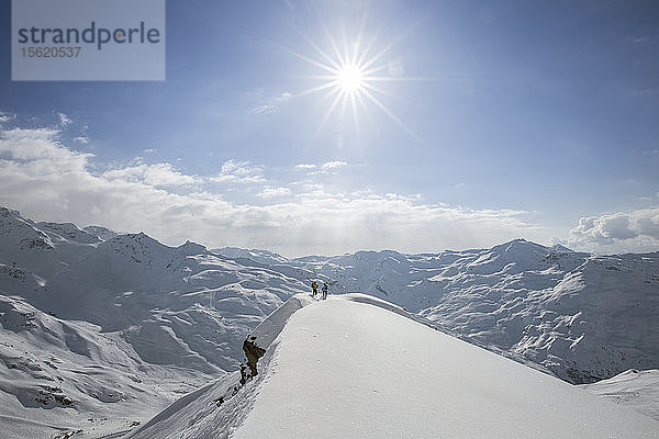 Zwei Skifahrer auf der Suche nach einer Linie am Rande eines Bergrückens