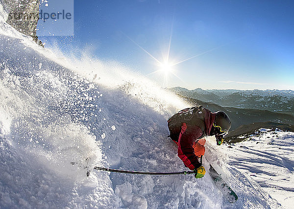 Ein Skifahrer nimmt eine harte Rechtskurve an einem sonnigen Frühlingstag in Whistler Blackcomb.