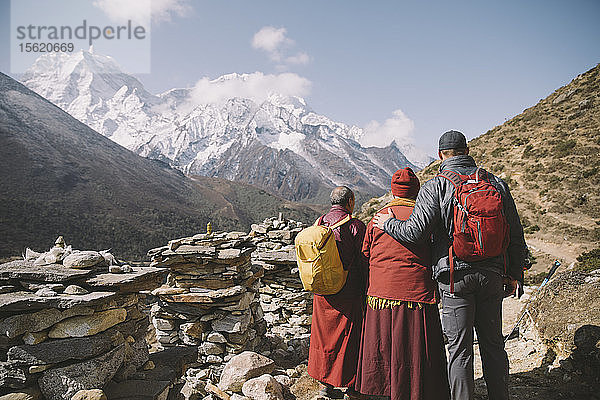 Zwei buddhistische Mönche posieren mit einem Himalaya-Trekker in der Everest-Region.