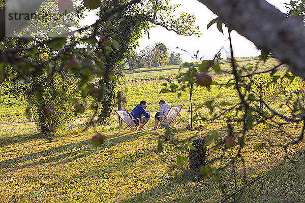 Zwei Gäste genießen die warmen Sonnenstrahlen auf dem Ferienhof Janezinovi im Dorf Ratecevo Brdo  das zur Gemeinde Ilirska Bistrica im Südosten Sloweniens gehört. Das Gehöft befindet sich auf einer Höhe von 500 m über dem Meeresspiegel  inmitten angenehmer Natur und weit weg von der Hektik der Stadt. Die umliegenden Wiesen  Weiden und Wälder sind ein idealer Ort  um sich zu erholen und mit der Natur in Kontakt zu kommen.