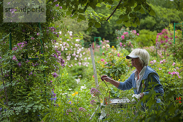 Eine Frau malt in den Gärten von Claude Monet in Giverny  Frankreich (verwaltet von der Fondation Claude Monet).