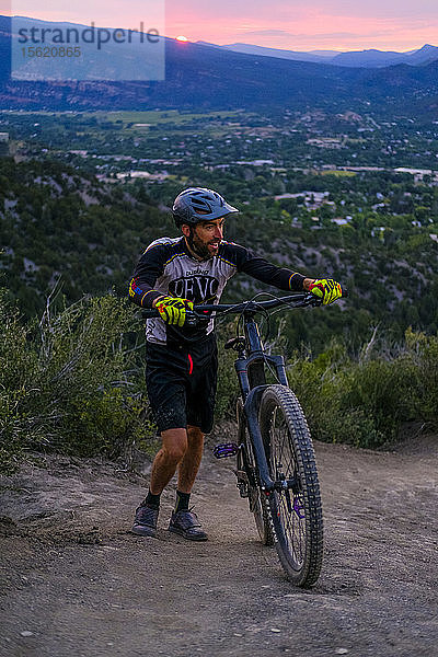 Männlicher Mountainbiker geht bei Sonnenuntergang den Hogs Back in der Nähe von Durango hinauf  Colorado  USA
