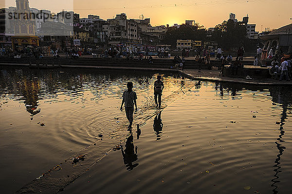 Jungen überqueren den Godavari-Fluss bei Sonnenuntergang  Nashik  Maharashtra  Indien.