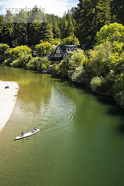 Eine Person paddelt an einem sonnigen Tag in Nordkalifornien auf einem Fluss.