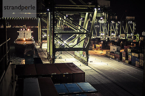 Containerterminal in Singapur bei Nacht  gesehen von der Brücke eines Containerschiffs.