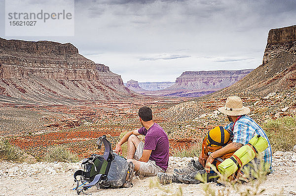 Zwei Rucksacktouristen blicken auf den Grand Canyon.