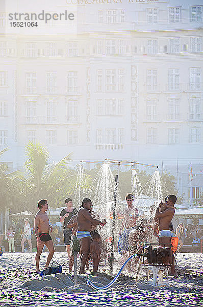 Männer und Kinder beim Duschen am Copacabana Strand in Rio De Janeiro  Brasilien