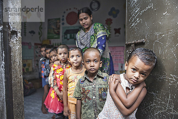 Kinder aus städtischen Slums besuchen die Vorschule. Dhaka  Bangladesch. Hier stehen die Schüler in einer Reihe.