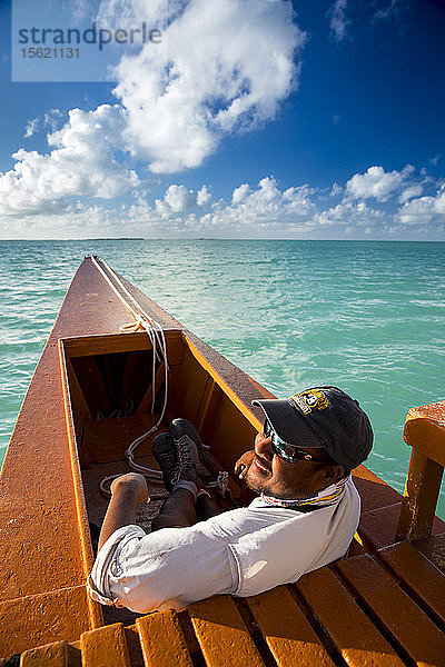 Wolken über einem Mann  der sich in einem Motorboot auf dem Wasser nahe der Weihnachtsinsel  Kiribati  entspannt