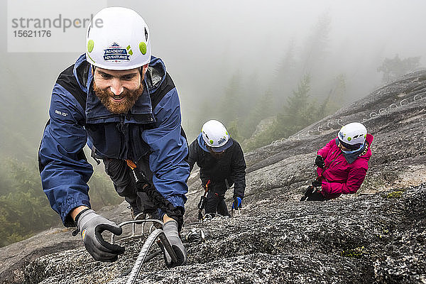 Ein Mann greift beim Besteigen des Klettersteigs in Squamish  British Columbia  nach der Metallsprosse.