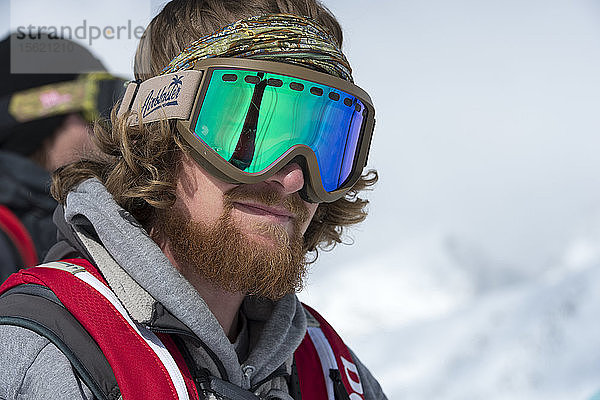 Porträt eines Snowboarders im Backcountry an einem sonnigen Tag