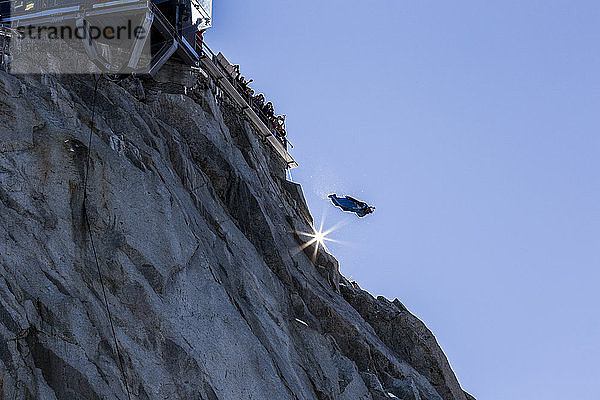 Wingsuit-Springer springt unter dem Jubel der Menge vom Berggipfel