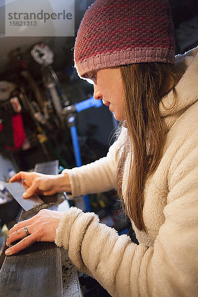 Seitenansicht einer Frau mit Strickmütze beim Skituning in einer Garage  Missoula  Montana  USA