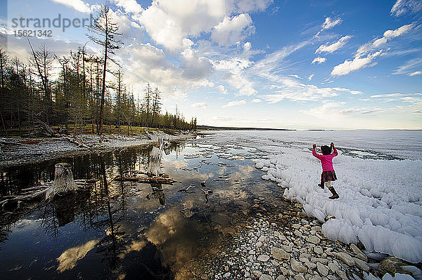 Kleines Mädchen spielt auf dem mit Eis bedeckten See in der Mongolei