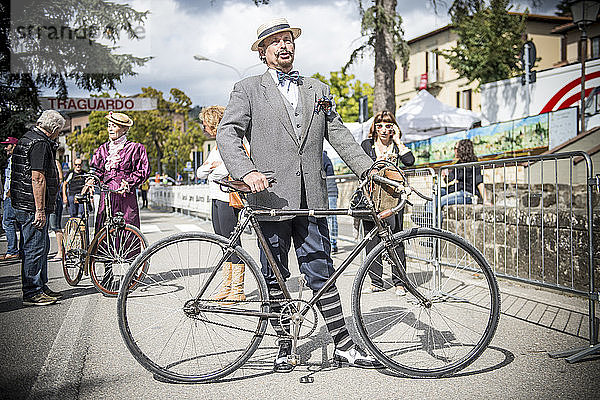 Ein elegant gekleideter Mann im Vintage-Stil. Die Eroica ist eine Radsportveranstaltung  die seit 1997 in der Provinz Siena stattfindet und bei der die Strecken meist auf unbefestigten Straßen mit alten Fahrrädern zurückgelegt werden. Normalerweise findet sie am ersten Sonntag im Oktober statt.