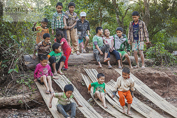 Kinder spielen und rutschen auf gespaltenen Bambusmatten am Strand in Muang Hat Hin  Laos.