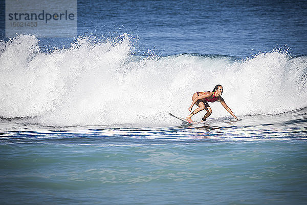 Totale Aufnahme einer Frau beim Surfen im Meer
