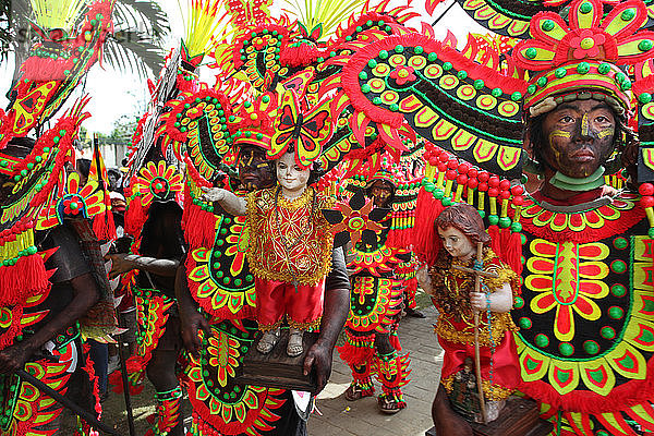 Menschen mit schwarz verschmierten Gesichtern in Stammeskostümen halten Jesuskind-Figuren beim Ati Atihan Festival  Kalibo  Aklan  Panay Island  Philippinen