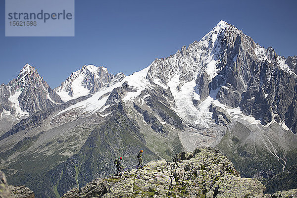 Zwei Bergsteiger auf einem felsigen Grat hoch über Chamonix in den französischen Alpen.