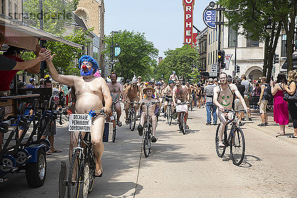 Eine große Anzahl nackter Radfahrer fährt auf der Straße  um gegen die Abhängigkeit von fossilen Brennstoffen zu protestieren  Madison  Wisconsin  USA