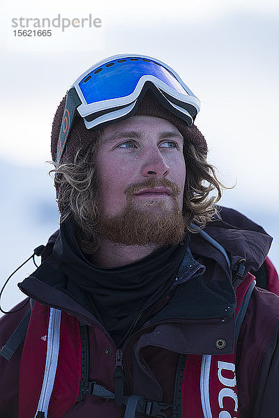 Porträt eines männlichen Snowboarders mit Blick in die Ferne