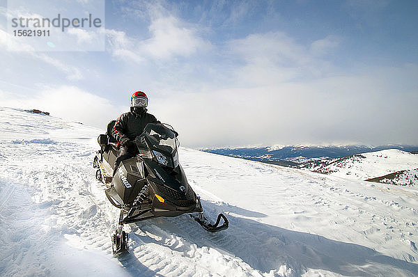Mann auf Schneemobil auf dem Gipfel eines Berges  Vail  Colorado