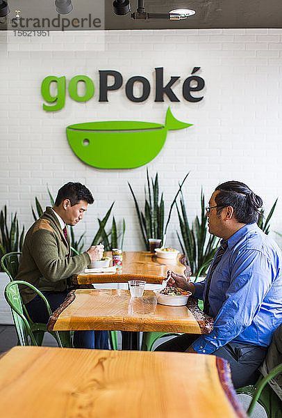 Foto von zwei männlichen Kunden in einem Restaurant  die Poke  ein traditionelles hawaiianisches Gericht  essen  Seattle  Washington State  USA